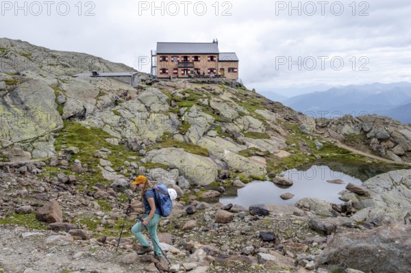 Mountaineer on a hiking trail, behind mountain hut Teplitzer Hütte, Stubai Alps, South Tyrol, Italy