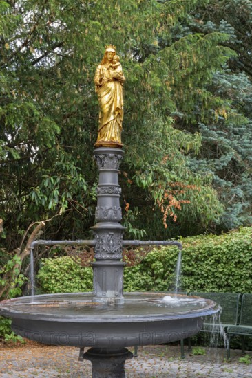 Fountain with a gilded statue of the Virgin Mary and baby Jesus, in front of St Briccius Church, Lindenstr.2 Wurmlingen, a district of Rottenburg