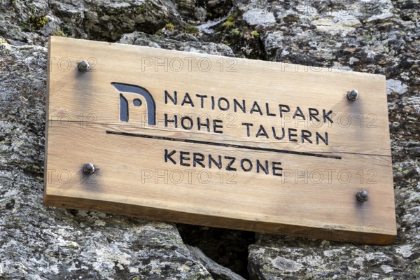 Wooden sign on rock, inscription Hohe Tauern National Park core zone, Schober group, Hohe Tauern National Park, Carinthia, Austria