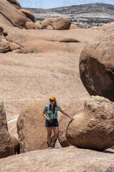 Tourist with camera, rock formation, Pontok Mountains, Spitzkoppe, Große Spitzkuppe Nature Reserve, Namibia