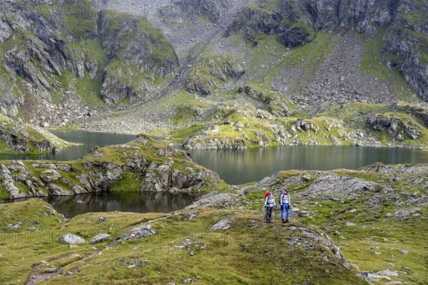 Two female mountaineers in a cloudy mountain landscape, Kreuzsee mountain lake, Wiener Höhenweg, Schober group, Hohe Tauern National Park, Carinthia, Austria