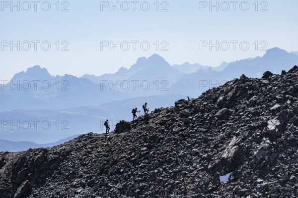 Hikers against the light on a ridge, Stubai Alps, South Tyrol, Italy