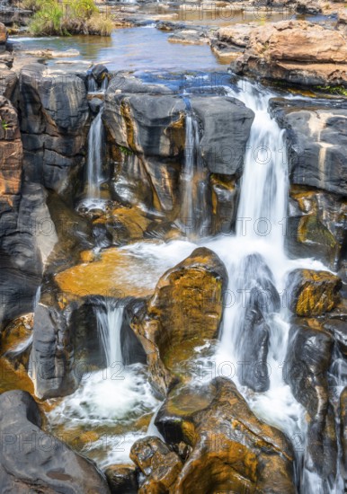 Waterfall on orange-coloured rock cliffs, long exposure, Blyde River, Bourke's Luck Potholes, Panorama Route, Mpumalanga, South Africa