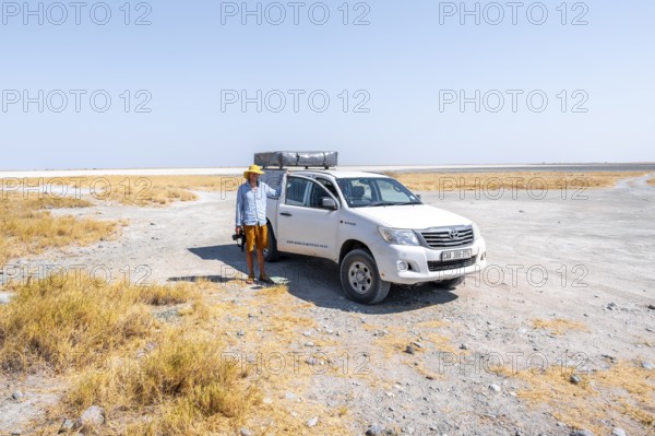 Tourist with off-road car exploring dry landscape, Kubu Island (Lekubu), Sowa Pan, Makgadikgadi salt pans, Botswana