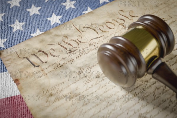United states constitution, gavel and american flag resting on table
