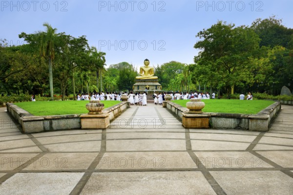 Pilgrims in front of a Buddha statue, Colombo, Sri Lanka