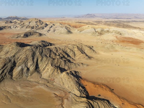 Arid plains, sand dunes and bare mountain ridges in the Tsondab Valley in the Namib Desert. Aerial view. Drone shot. Namibia