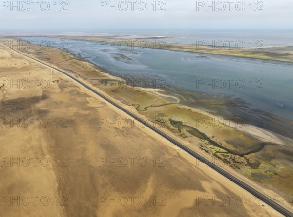 The Walvis Bay Lagoon between Namib Desert and Atlantic Ocean. At low tide with scattered flamingos. Aerial view. Drone shot. Namibia