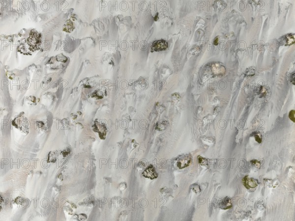 Small sand heaps form around the sparse vegetation in the Namib Desert. Aerial view. Drone shot. Skeleton Coast National Park, Namibia