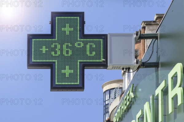 Thermometer in green pharmacy screen sign displays extremely hot temperature of 36 degrees Celsius during heatwave, heat wave in summer in Belgium