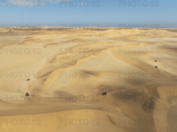 Quad bikes in the dunes of the Namib Desert in the vicinity of the coastal town of Swakopmund. Aerial view. Drone shot. Namibia
