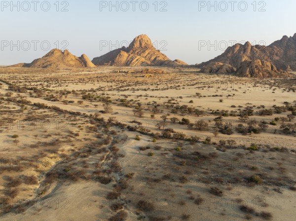 The isolated Spitzkoppe mountain (1728 m) majestically rises above the surrounding desert plains. Aerial view. Drone shot. Damaraland, Namibia