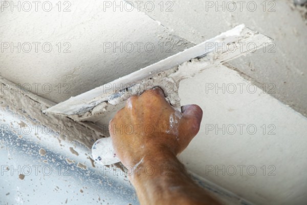 Plasterer smoothing and levelling interior walls