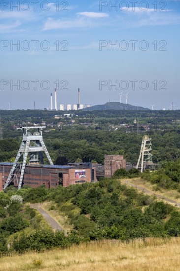 The double headframe of the disused Ewald mine, shaft 7, on the right headframe shaft 2, in Herten, in the background the UNIPER coal-fired power station Scholven, Gelsenkirchen, Scholten spoil tip with 2 wind turbines, North Rhine-Westphalia, Germany