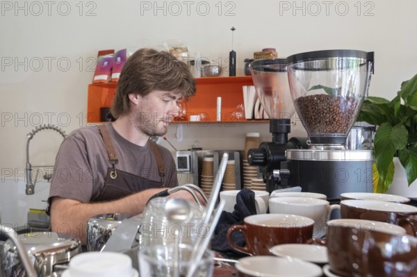 Midland, Michigan - An employee makes coffee at Chef Sergey's Bakery, a popular shop owned by four refugees from Ukraine. Several hundred thousand Ukrainians have been granted refugee status in the U.S. since Russia invaded their homeland, but the Trump Administration is considering whether to revoke their legal status