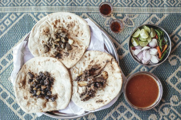 Traditional camel restaurant in Salalah, three kinds of camel meat (dry braised, boiled and grilled/baked), traditionally served with bread and chutney, Dhofar, Oman