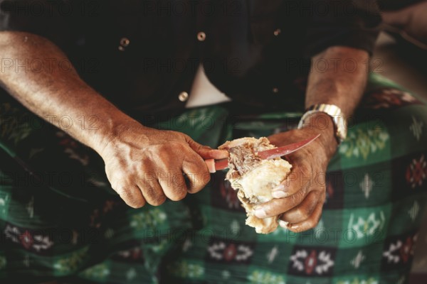 Traditional camel restaurant in Salalah, a guest eats a piece of boiled camel, Dhofar, Oman