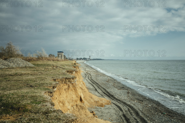 Beach and view of the city. The higher building is the 16-florr-building, as locals call it. Investors wanted to build a hotel there, but when the war broke out, the project was abandoned, Ochamchira, Abkhazia, Georgia