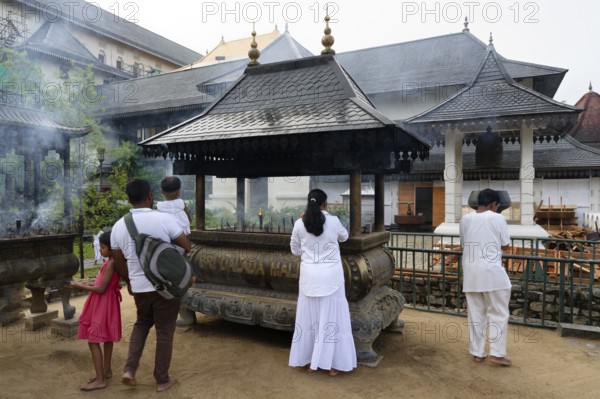 Temple of the sacred Tooth Relic or Sri Dalada Maligawa, Pilgrims burning incense, Kandy, Sri Lanka