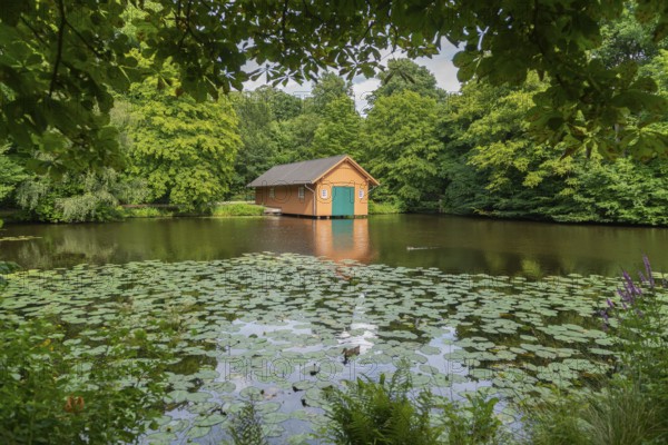 Boathouse at Meiereisee in Bürgerpark from 1866, landscape park with rivers and lakes, garden monument, attraction, recreation, groups of trees, nature, water reflection, water lilies, city state of Bremen, Germany