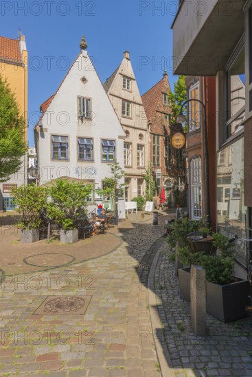 Renovated Schnoor neighbourhood with small shops, galleries, restaurants, cafés and residential buildings, Gängeviertel in the old town, former fishermen's and boatmen's settlement, narrow alleyways, pedestrian zone, numerous listed buildings, classicist, historicist, baroque and renaissance architecture, gabled houses, greenery, tourist attraction, destination, pleasure, Hanseatic city of Bremen, Germany