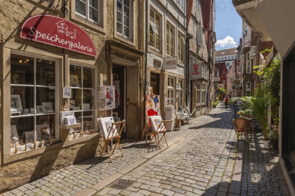 Renovated Schnoor neighbourhood with small shops, galleries, restaurants, cafés and residential buildings, Gängeviertel in the old town, former fishermen's and boatmen's settlement, narrow alleyways, pedestrian zone, numerous listed buildings, architecture of classicism, historicism, baroque and renaissance, greenery, tourist attraction, destination, pleasure, Hanseatic city of Bremen, Germany