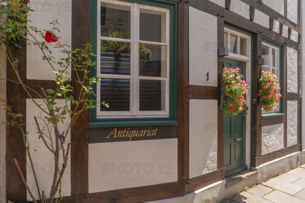 Schmaler Weg Hinter der Balge, antiquarian bookshop, detail, entrance, half-timbered house, renovated Schnoor district with small shops, galleries, restaurants, cafés and residential buildings, Gängeviertel in the old town, former fishermen's and boatmen's settlement, narrow alleys, pedestrian zone, numerous listed buildings, classicist, historicist, baroque and renaissance architecture, flower pots, tourist attraction, destination, pleasure, Hanseatic city of Bremen, Germany