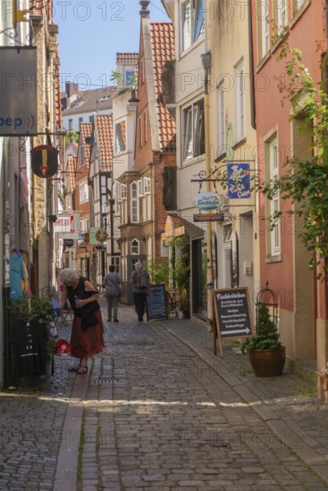 Renovated Schnoor district with small shops, galleries, restaurants, cafés and residential buildings, half-timbered houses, tourists, Gängeviertel in the old town, former fishermen's and boatmen's settlement, narrow alleyways, pedestrian zone, numerous listed buildings, classicist, historic, baroque and renaissance architecture, tourist attraction, destination, pleasure, Hanseatic city of Bremen, Germany