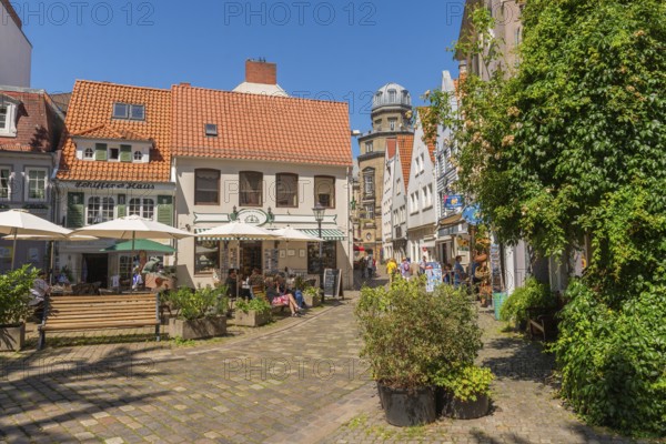 Renovated Schnoor district with small shops, square, skipper's house, flower pots, wall greenery, people, galleries, restaurants, cafés and residential buildings, Gängeviertel in the old town, former fishermen's and skippers' settlement, narrow alleys, pedestrian zone, numerous listed buildings, classicist, historicist, baroque and renaissance architecture, tourist attraction, destination, pleasure, Hanseatic city of Bremen, Germany