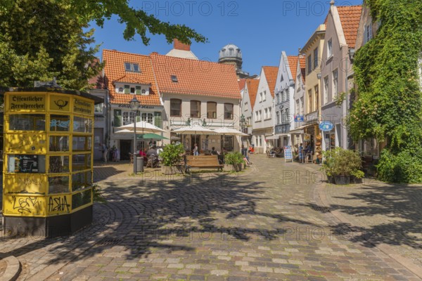 Renovated Schnoor district with small shops, square with historic public telephone, telephone box, skipper's house, flower pots, green walls, people, galleries, restaurants, cafés and residential buildings, Gängeviertel in the old town, former fishermen's and skippers' settlement, narrow alleys, pedestrian zone, numerous listed buildings, classicist, historic, baroque and renaissance architecture, tourist attraction, destination, pleasure, Hanseatic city of Bremen, Germany