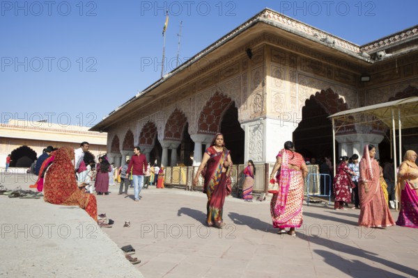 Colourfully dressed Indians at the Govind Dev Ji Hindu temple in the old town, Jaipur, Rajasthan, India
