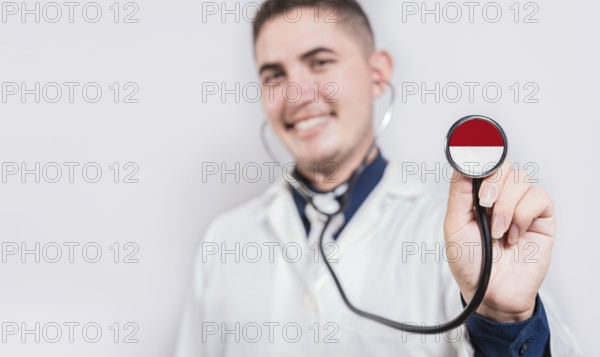 Doctor showing stethoscope with Monaco flag. Monaco national healthcare concept