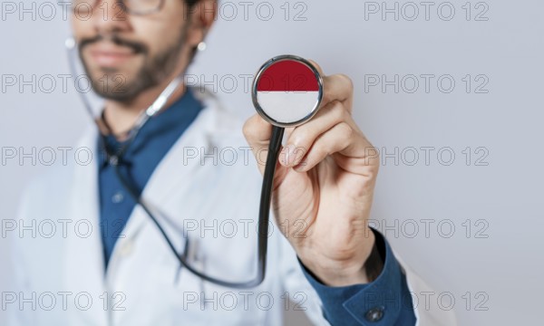 Doctor holding stethoscope with Monaco flag. Monaco health and care concept, Monaco flag on stethoscope