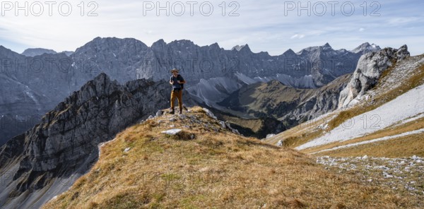 Mountaineers in front of a picturesque mountain landscape in autumn, view of the rocky ridge of the Hinterautal-Vomper chain, RiÃŸtal in the Eng, Karwendel, Tyrol, Austria