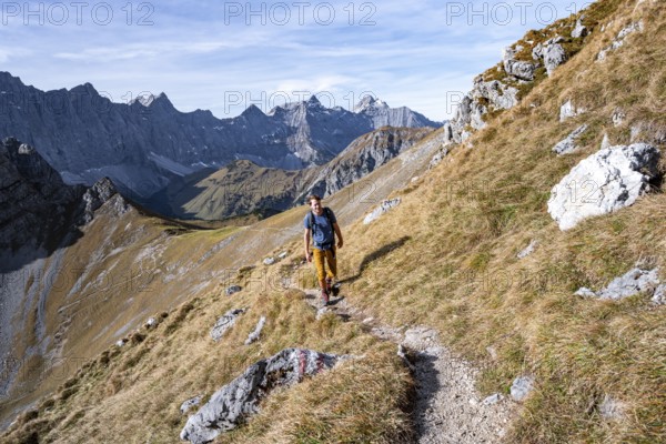 Mountaineers on a hiking trail at the Gamsjoch, picturesque mountain landscape in autumn, view of the rocky mountain ridge of the Hinterautal-Vomper chain, RiÃŸtal in the Eng, Karwendel, Tyrol, Austria