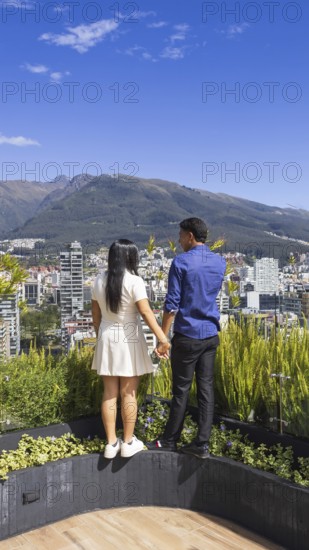 Quito, Ecuador, May 2 2025: Young tourist couple overview Carolina Park modern condominiums in Quito central business financial district