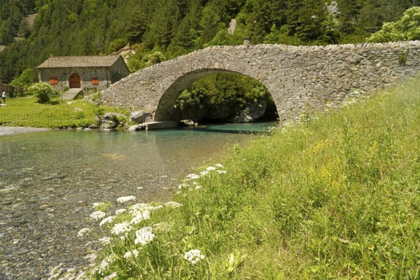 The Romanesque bridge Puente RomÃ¡nico de San NicolÃ¡s de Bujaruelo over the River Ara in the Bujaruelo Valley or Valle de Bujaruelo and the church Iglesia de San NicolÃ¡s de Bujaruelo near Torla-Ordesa, Spain