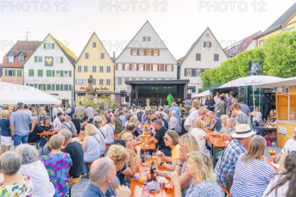 People gather on a market square to enjoy the summer evening, 950 years Weil der Stadt ceremony, Böblingen district, Germany