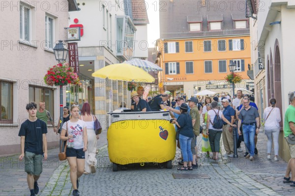People stroll through a narrow alley in the old town centre, flanked by shops and flowers, 950th anniversary of Weil der Stadt, Böblingen district, Germany
