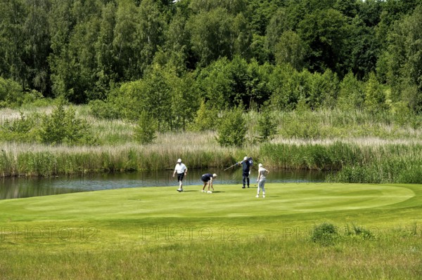 Golfers on the putting green of the golf course at the Golfhotel Balmer See Hotel-Golf-Spa, Balm, Island Usedom, Mecklenburg-Vorpommern, Germany