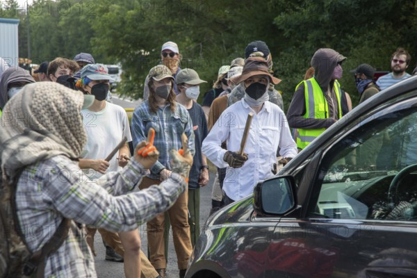 Baldwin, Michigan USA - 4 July 2025 - Activists rally against the North Lake Correctional Facility, which has just been reopened as the largest immigrant detention center in the Midwest. The rural Michigan facility is owned by the GEO Group and will house immigrants detained by ICE. One group of protesters banged noisemakers and blocked a car from entering the facility