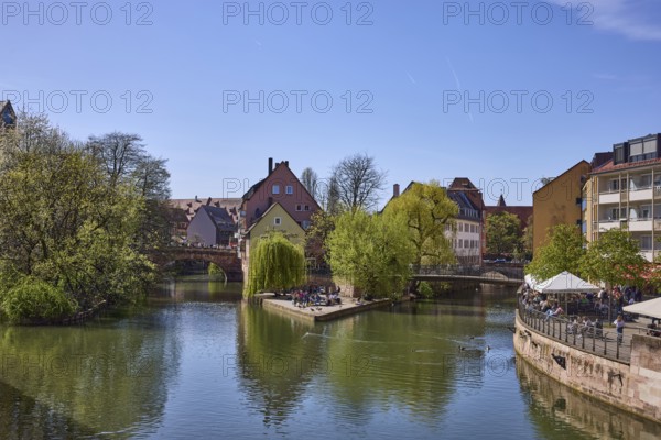 Flea market island, river Pegnitz, river island, pedestrian bridges, historic buildings, trees, reflections, water surface, outdoor area, gastronomy, parasols, visitors as secondary motif, backlight, blue sky, cloudless, KarlsbrÃ¼cke, Schleifersteg, Nuremberg, Middle Franconia, independent city, Bavaria, Germany