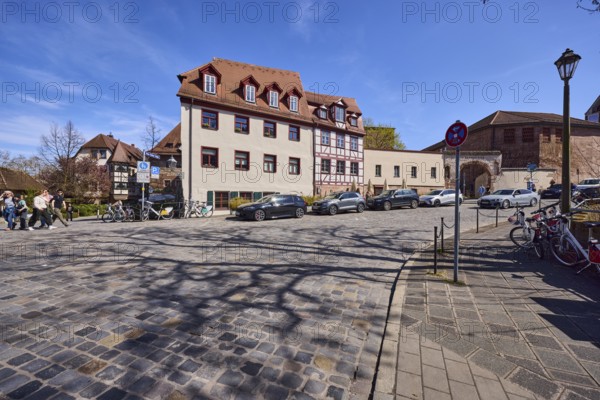 Street, cobblestone pavement, historic buildings, half-timbered house, lantern, parking lane with vehicles, blue sky, cirrostratus clouds, intersection Peter-Vischer-StraÃŸe with wasp nest, Nuremberg, Middle Franconia, independent city, Bavaria, Germany
