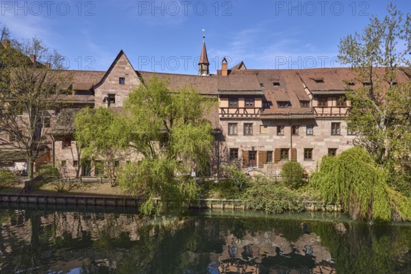 River Pegnitz, historic buildings, Babylon willow (Salix babylonica), trees, symmetrical reflections, water surface, blue sky, cirrostratus clouds, Vordere Insel SchÃ¼tt, Nuremberg, Middle Franconia, independent city, Bavaria, Germany