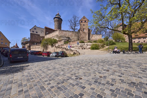 Kaiserburg, castle, castle chapel, round tower, trees, lawn, parking boxes, parking lane, vehicles, cobblestones, blue sky, cirrostratus clouds, intersection BurgstraÃŸe with Am Ã–lberg, Nuremberg, Middle Franconia, independent city, Bavaria, Germany