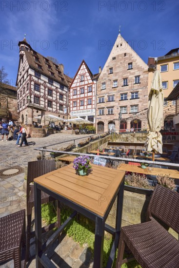 Pilatushaus, town house, late Gothic architectural style, historic buildings, half-timbered houses, cobblestones, outdoor area of a restaurant with tables, chairs and parasol, square, pedestrians as secondary motif, super wide angle, blue sky, Beim TiergÃ¤rtnertor, Obere Schmiedgasse, TiergÃ¤rtnertorplatz, cirrostratus clouds, Nuremberg, Middle Franconia, independent city, Bavaria, Germany