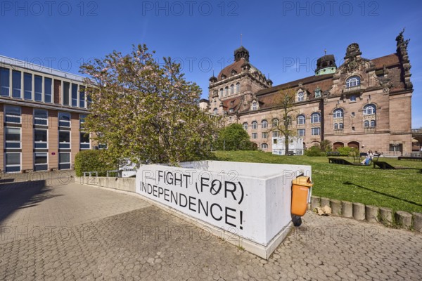 Nuremberg State Theatre, architect Christian Heinrich Seeling, theatre, opera, blossoming tree, Japanese flowering cherry (Prunus serrulata), wall, fight for independence, public rubbish bin, blue sky, cloudless, Richard-Wagner-Platz, Nuremberg, Middle Franconia, independent city, Bavaria, Germany