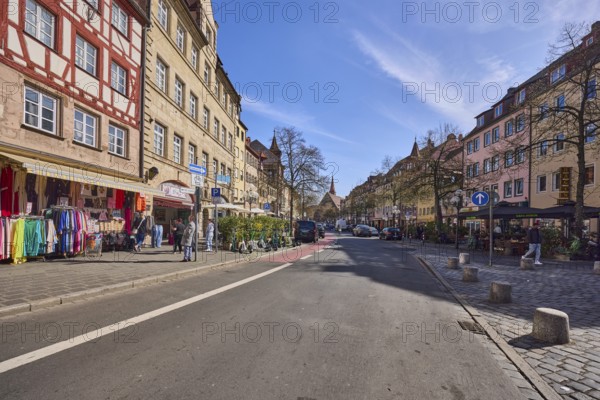 Old town, street, historic houses, half-timbered house, retail shops, fashion shop, trees, bollards, pedestrians as secondary motif, blue sky, cirrostratus clouds, LudwigstraÃŸe, Nuremberg, Middle Franconia, independent city, Bavaria, Germany