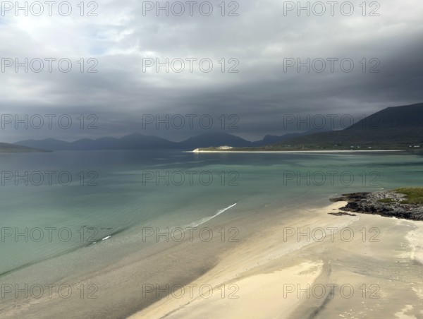 Stormy coastal view with grey sky and calm sea to the shore of a wide bay, Outer Hebrides, Isle of Harris, Scotland, United Kingdom