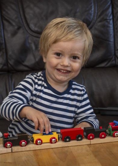 Blond boy, 2 years old, playing with toy train in Ystad, SkÃ¥ne County, Sweden, Scandinavia